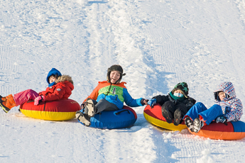 눈썰매를 타고 내려오는 아이들