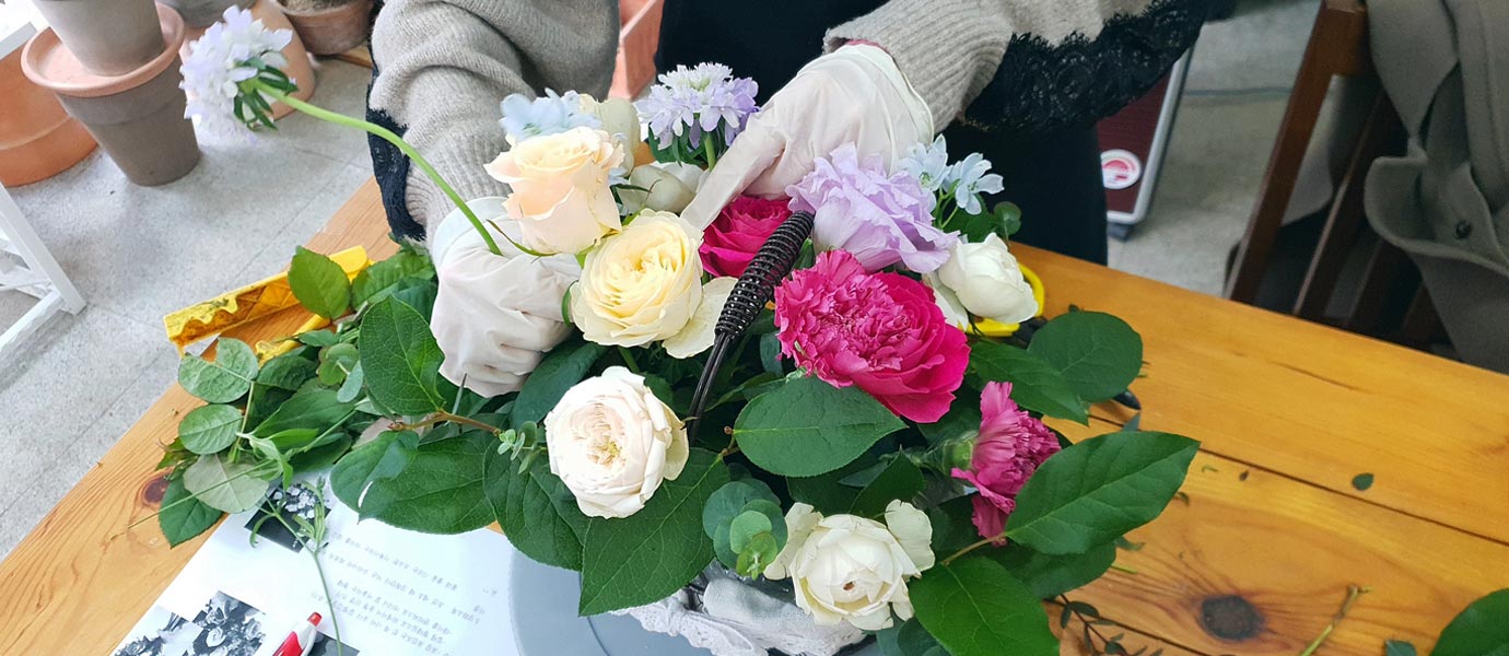 꽃바구니에 꽃꽂이 중인 사진