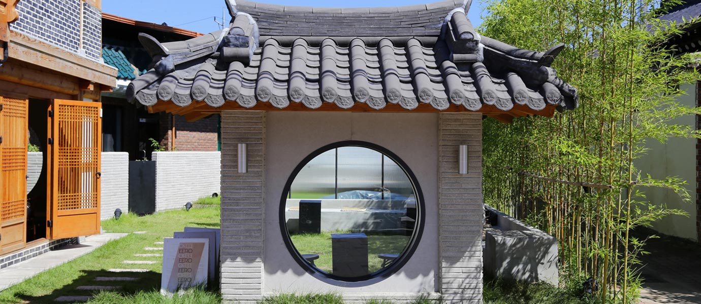 이이로드커피 포토존 : 기와를 얹은 담벼락에 원형의 창이 나있다.