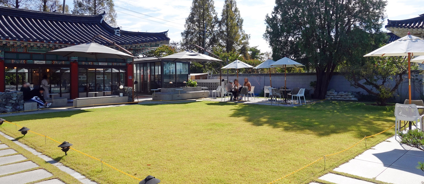 카페 메이플 전경 - 야외테이블에서 커피를 마시는 사람들