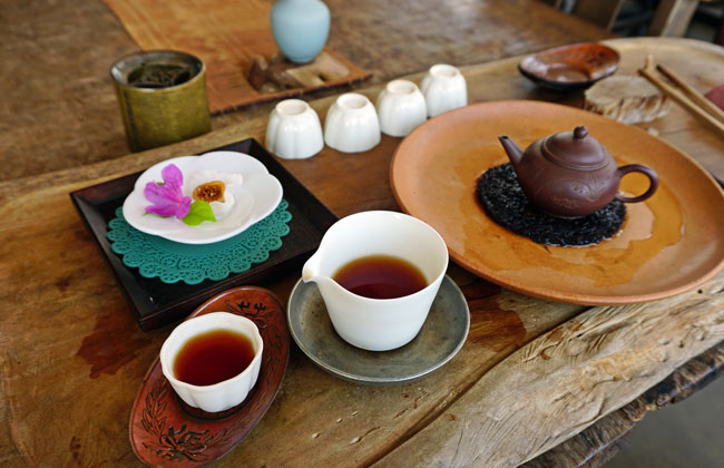 전통차가 담겨잇는 잔과 주위로 놓여있는 다도 도구들