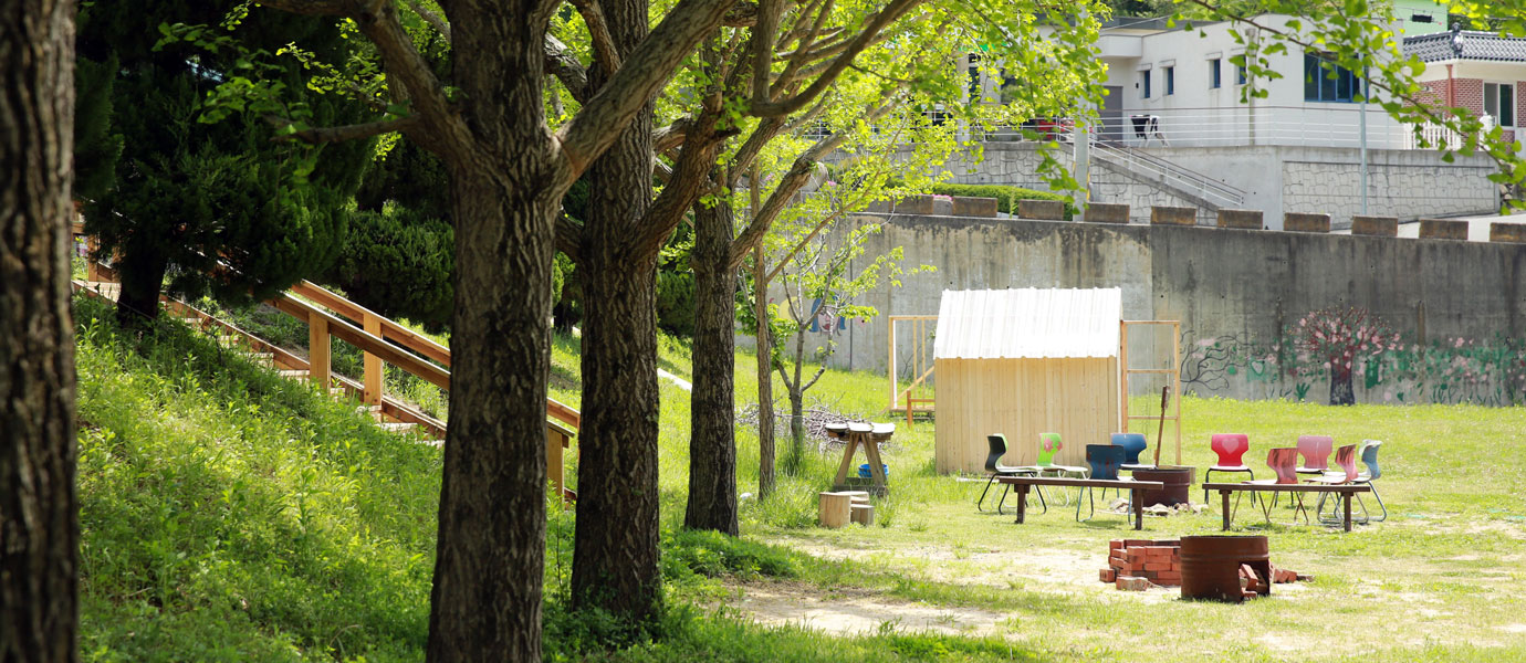 우라분교 운동장에 장작 불 피울공간 주위로 알록달록 의자가 놓여있다
