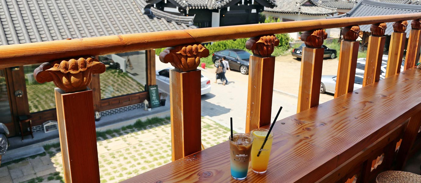 손카페앤펍 2층 툇마루 위에 음료가 올라가있고 그 건너로 황리단길이 보인다.