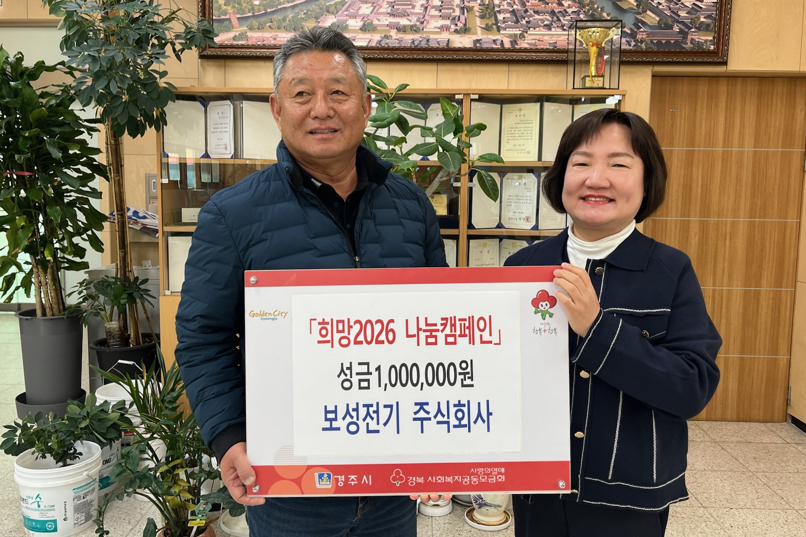 보성전기(주) 정윤균 대표(왼쪽)가 지난 29일 동천동 행정복지센터에서 배경혜 동천동장에게 이웃돕기 성금 100만 원을 전달한 뒤 기념촬영을 하고 있다.